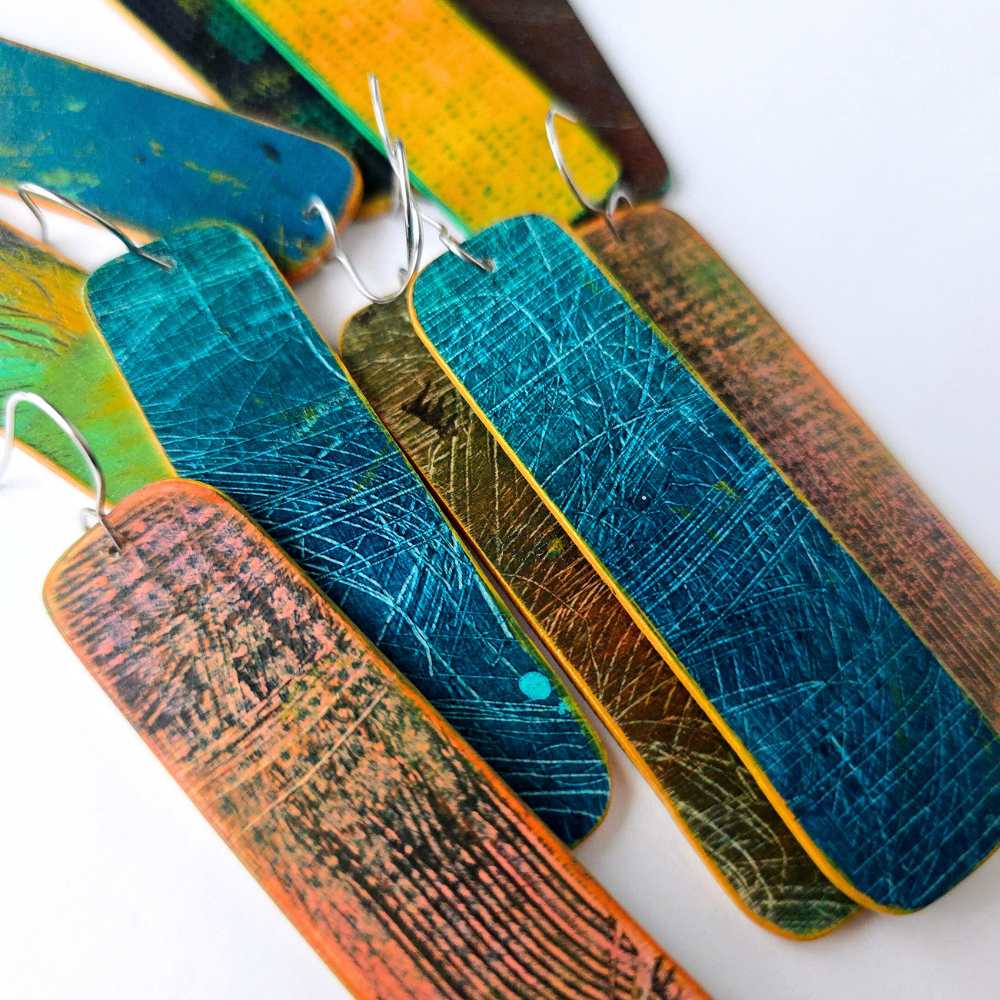 Original work by Wendy Weaver-Orlowski, including hand-painted wood jewelry and small studio collections